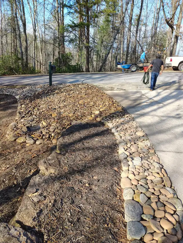 River rock border installed along a driveway in Asheville, NC